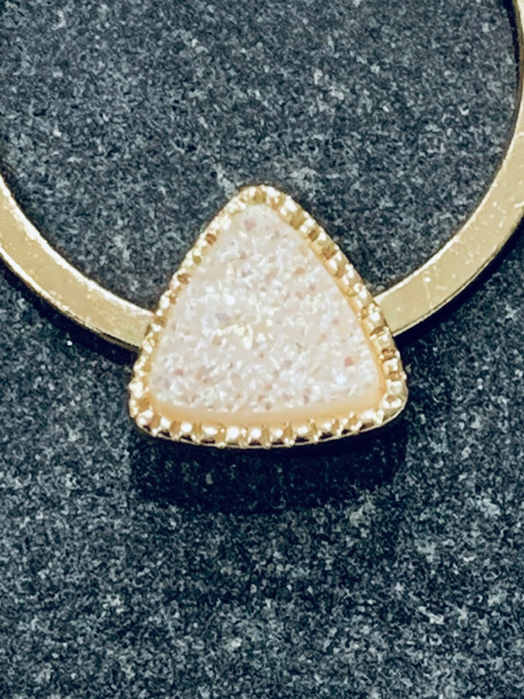 Close up of white druzy on gold hoop earring
